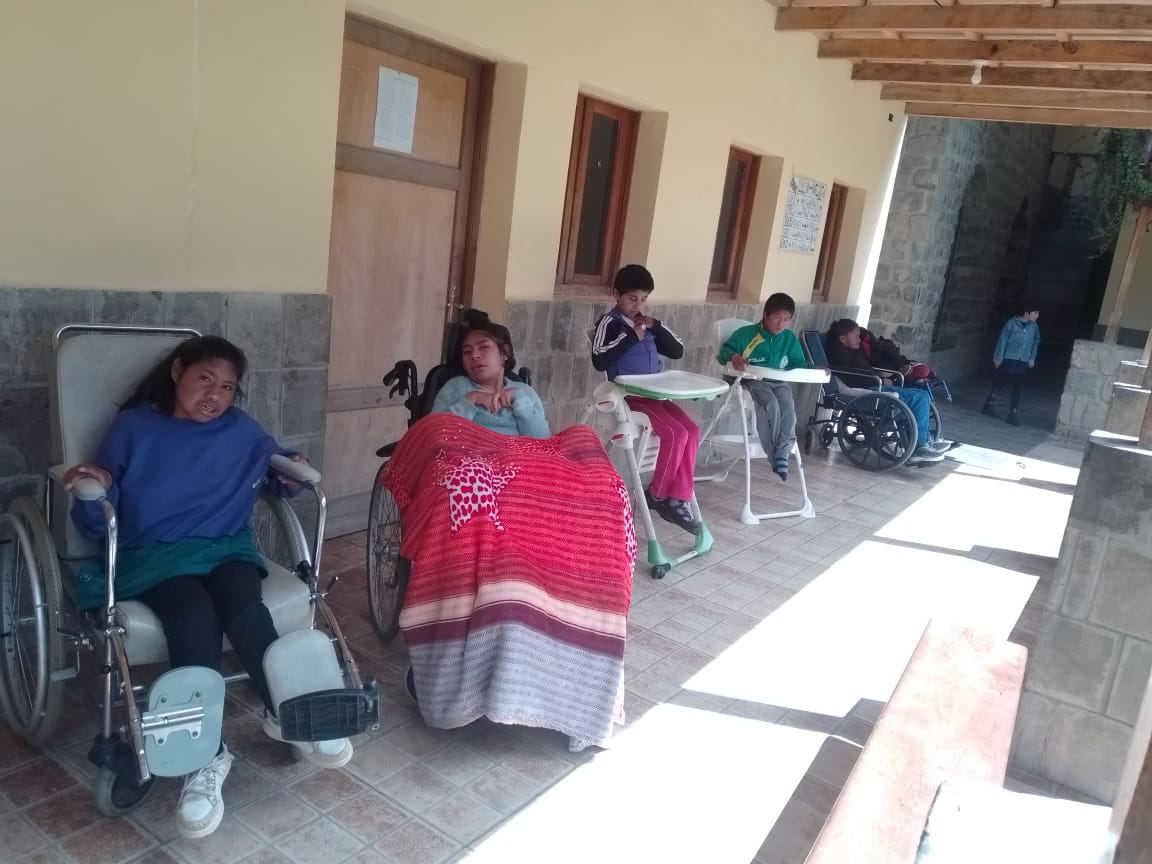 Corredor del centro con jóvenes en sillas de ruedas y cuidadores